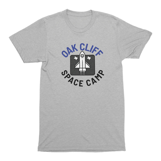 Heather gray t-shirt with 'Oak Cliff Space Camp' graphic featuring a rocket with Texas shaped designs beside it on a transparent  background